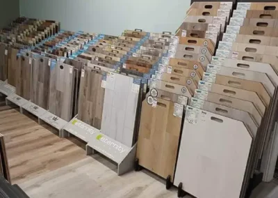 Rows of various vinyl and laminate flooring samples displayed in a store